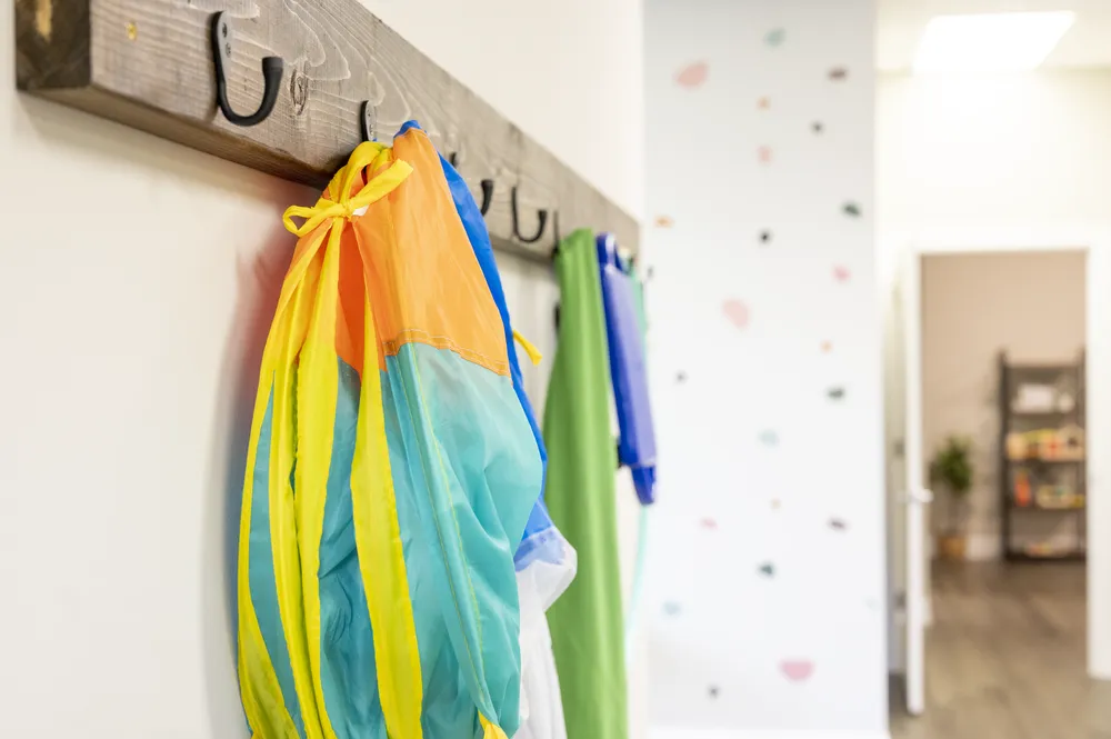 Sensory swings and equipment hanging on wall hooks
