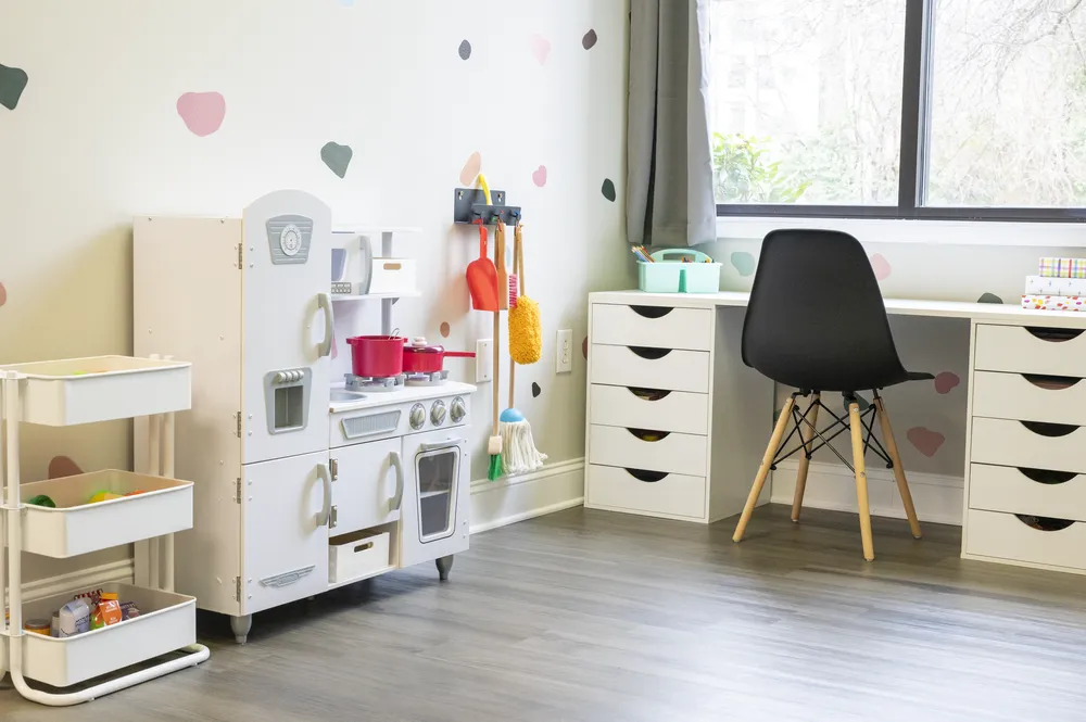 Therapy room with a play kitchen, storage drawers, and natural light